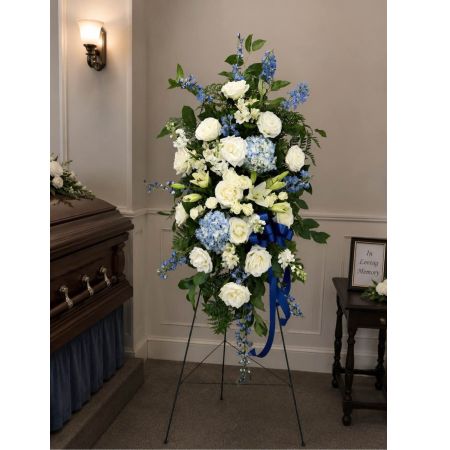 Blooms of Wayne Wayne - Escape to a tropical paradise with our Blue Caribbean Spray. This stunning arrangement evokes the serenity of crystal-clear waters and sun-drenched skies.  A vibrant explosion of blue hydrangeas, delphinium and white roses are expertly combined to create a sense of cool refreshing beauty. Imagine this piece brightening a room and offering comfort during times of sympathy. The varying textures and heights create visual interest while the overall effect is one of peaceful elegance.  It's more than just flowers; it's a moment of tranquility delivered. 