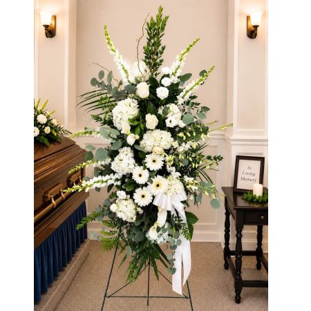 Blooms of Wayne Wayne - Express your deepest sympathy and honor a cherished life with our White Tribute Spray. This stunning arrangement is a beacon of peace and remembrance crafted with a delicate artistry that speaks volumes where words cannot. Masses of pure white blooms cascade and swirl evoking a sense of serene beauty and respectful farewell. Imagine the quiet grace it will bring to a memorial service or the comfort it offers a grieving heart. The fragrance is light and ethereal – a whisper of clove and subtle sweetness – creating a truly peaceful atmosphere.  This isn’t simply flowers; it’s an embrace of support during a difficult time a visual representation of heartfelt condolences and a lasting tribute to a life beautifully lived. Perfect for funerals memorial services or expressing sympathy to a friend or family member.