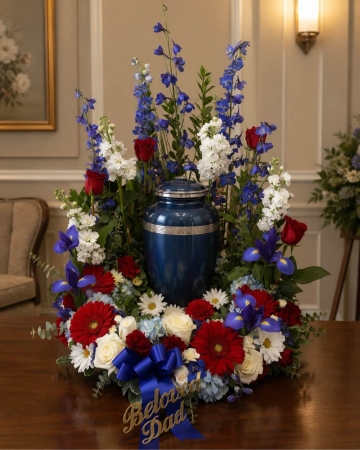 Blooms of Wayne Wayne - Show your reverence and honor with the striking beauty of our Patriotic Urn Tribute. This impressive floral arrangement is a heartfelt expression of respect and remembrance perfect for memorial service. A majestic urn overflows with a vibrant cascade of red white and blue blooms creating a stunning visual tribute that speaks volumes. Imagine the comfort it will bring a beautiful symbol of gratitude and lasting affection. The delicate fragrance will gently fill the space evoking peaceful memories and a sense of dignified serenity. Send this exquisite urn arrangement to express your deepest sympathies or to celebrate a life well-lived.