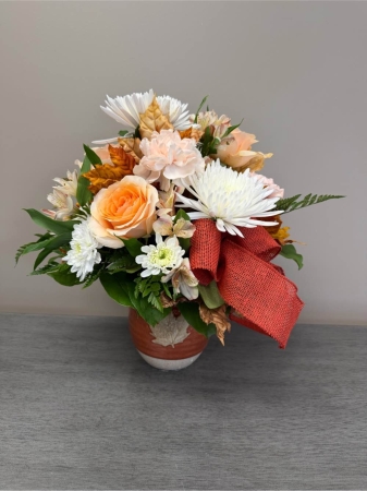 Blooms of Wayne Wayne - Bring the warmth and beauty of the autumn harvest into your home with our 'Fall Pitcher Perfect' arrangement. This stunning centerpiece overflows with the rich textures and colors of the season presented in a charming rustic pitcher. Imagine the soft glow of candlelight reflecting off the velvety petals as the sweet earthy fragrance fills the air. This isn’t just flowers; it’s a feeling – a cozy gathering, a thankful moment, a simple celebration of nature’s bounty. Perfect for your own table or as a heartfelt gift to express gratitude, warmth or simply to brighten someone’s day. Create a welcoming ambiance with this effortlessly elegant display of autumnal splendor.
