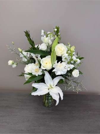 Blooms of Wayne Wayne - Embrace the purity and tranquility of 'Everything Is Going To Be All White' a stunning floral arrangement designed to bring a sense of calm and renewal to any space. This exquisite bouquet is a symphony of white blossoms each carefully selected for its delicate beauty and fragrance. Imagine the soft clean aroma gently filling a room evoking feelings of peace and serenity.  Whether you're expressing sympathy, offering congratulations or simply seeking a moment of quiet grace this arrangement speaks volumes. The lush textured petals create a visually captivating display perfect for adorning a bedside table, brightening a reception area or offering solace during times of grief.  'Everything Is Going To Be All White' is more than just flowers; it’s a gesture of hope, a symbol of fresh beginnings and a comforting embrace in bloom. Send this beautiful bouquet to let someone know you are thinking of them and that brighter days are ahead.