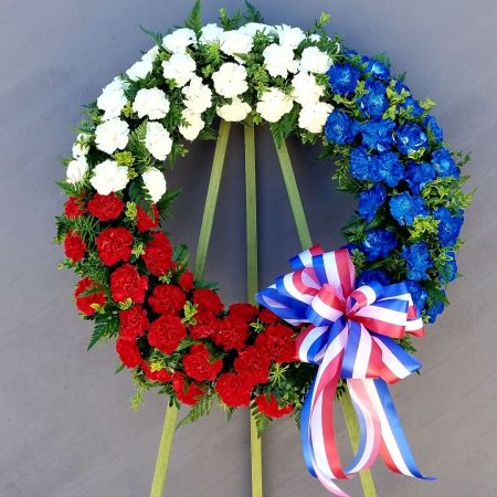 Log Cabin Florist Bakersfield - This is a large 24" wreath in patriotic tones to honor your family Hero. We are also able to insert a photo of your loved one or add a memorial banner through the center of the wreath to convey your sentiment.