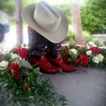 Log Cabin Florist Bakersfield - This Serpentine shaped floral tribute is a beautiful design when you are wanting to feature both a photograph and an urn or personal items. Colors may also be customized and is suitable for either a man or a woman. Design is  over 48" long and 24" wide.