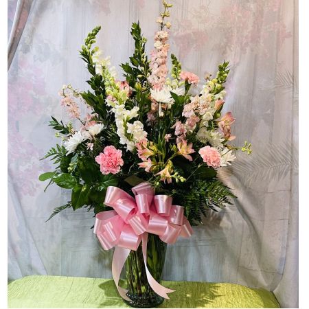 Log Cabin Florist Bakersfield - Beautiful Sympathy arrangement for the home of Pink Larkspur, White snapdragons, Pink alstromeria, Pink carnations and white pom poms in a vase with pink bow. Approx. 36"H x 23"W***Flowers and container may be substituted depending upon availability***