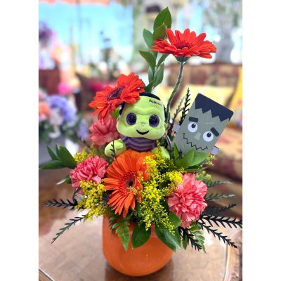 DiBella Flowers & Gifts Las Vegas - Bring a playful touch of spooky charm to your Halloween décor with the Frankenblooms! Featuring bright orange gerbera daisies and cheerful carnations arranged in a festive pumpkin-style container, this arrangement is topped off with a cuddly Frankenstein plush for extra fun. Accented with lush greenery and a Frankenstein detail, it’s the perfect centerpiece for Halloween parties, a gift for kids, or a spirited way to brighten someone’s day.
