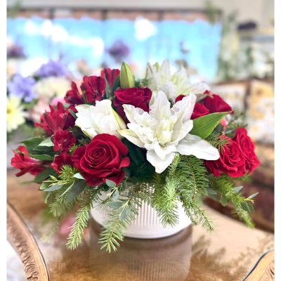 DiBella Flowers & Gifts Las Vegas - "Holiday Romance" is a festive and elegant floral arrangement designed to spread seasonal cheer and affection. Classic red roses, delicate white flowers, and soft orchids are arranged among holiday greens, creating a timeless mix of color and texture. Designed in a white ceramic vase, this piece evokes the cozy magic of the holidays - ideal for gifting or decorating your holiday table.