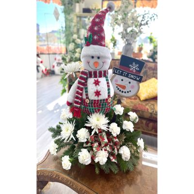 DiBella Flowers & Gifts Las Vegas - Snow Much Cheer is a heartwarming holiday arrangement that captures the magic of winter smiles and festive charm. Featuring a cheerful snowman nestled among fresh evergreens, snowy white blooms, and seasonal textures, it brings instant joy to any space. Accents of plaid, ribbon, and winter whimsy add a cozy, nostalgic touch. Perfect for spreading smiles, this arrangement is snow much fun and full of holiday cheer.