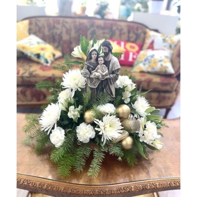 DiBella Flowers & Gifts Las Vegas - This serene holiday arrangement features a timeless Holy Family centerpiece surrounded by lush evergreens, soft white blooms, and elegant gold accents. The crisp whites and natural greens create a peaceful, reverent feel that reflects the beauty of the season. Perfect for honoring faith and tradition, it brings a sense of warmth, grace, and quiet joy to any space.