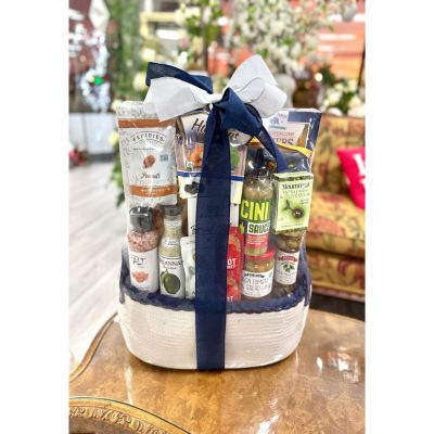 DiBella Flowers & Gifts Las Vegas - This elevated goodie basket is packed with gourmet pantry favorites, including savory snacks, premium oils, flavorful sauces, nuts, and sweet touches, all neatly arranged and finished with a crisp navy and white bow—perfect for food lovers who enjoy a little indulgence with everyday essentials.