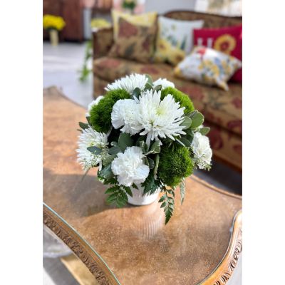 DiBella Flowers & Gifts Las Vegas - This elegant winter arrangement features crisp white blooms presented with rich evergreen textures, all designed in a classic white ceramic vase for a clean, timeless look. Soft layers of white florals are beautifully balanced with lush green accents, creating a serene and cozy seasonal statement. Perfect for winter gatherings, sympathy sentiments, or adding calm sophistication to any space.