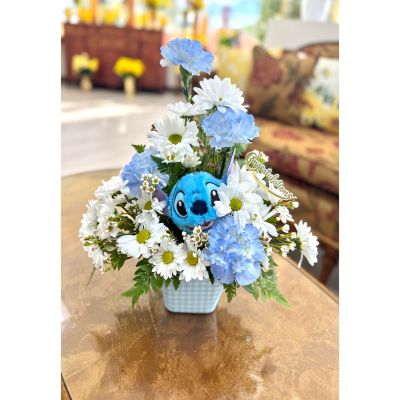 DiBella Flowers & Gifts Las Vegas - Baby Blue Blessing is a joyful and heartwarming arrangement designed to celebrate a precious new beginning. Soft blue blooms and crisp white daisies are beautifully nestled with fresh greenery, creating a calm and uplifting palette. An adorable plush companion peeks out from the center, adding a sweet touch of comfort and charm. Presented in a blue gingham container and finished with a celebratory accent, this arrangement is a perfect way to welcome baby with love and blessings. 