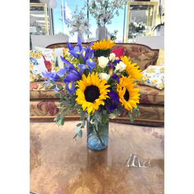 DiBella Flowers & Gifts Las Vegas - Bright and cheerful, Beauty in Blue features bold sunflowers, vibrant blue irises, and soft white roses arranged in a blue glass vase for a fresh, uplifting look. Lovely for Mother's Day, birthdays, get well wishes, or just because, it’s a standout choice for same-day flower delivery Las Vegas and thoughtful last-minute gifts. Handcrafted by DiBella Flowers and Gifts, this design is ideal for anyone searching for sunflower bouquet Las Vegas same-day delivery with a pop of color.