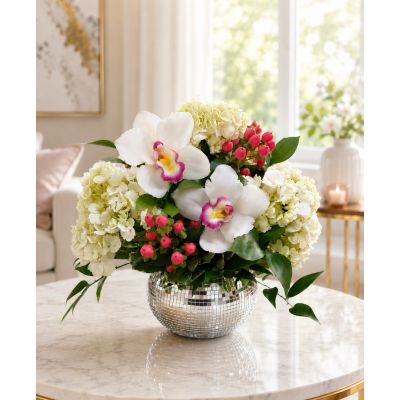 DiBella Flowers & Gifts Las Vegas - Orchid Gleam brings a touch of modern elegance to any occasion with graceful white orchids, lush hydrangea, vibrant pink accents, and fresh greenery arranged in a shimmering mirrored vase. Perfect for birthdays, anniversaries, thank-you gifts, or simply making someone’s day brighter. Handcrafted by DiBella Flowers and Gifts with delivery available throughout Las Vegas.
