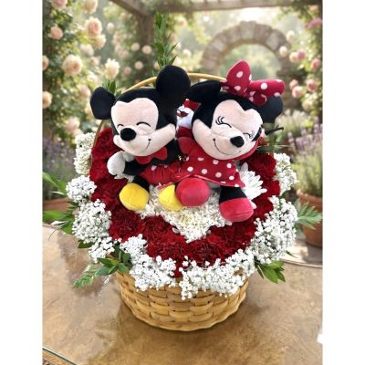 DiBella Flowers & Gifts Las Vegas - Minnie and Mickey’s Garden is a sweet and playful floral arrangement featuring Minnie and Mickey plush keepsakes surrounded by rich red carnations, delicate white blooms, and fresh greenery in a charming woven basket. Perfect for birthdays, anniversaries, romantic surprises, or Disney fans of any age. Handcrafted by DiBella Flowers and Gifts with flower delivery available throughout Las Vegas.