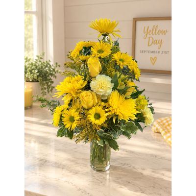 DiBella Flowers & Gifts Las Vegas - Say Hello, Yellow! with a cheerful mix of sunny yellow blooms accented by fresh greenery and arranged in a clear glass vase. Created for National Yellow Flower Day on September 21, this bright bouquet is a fun way to send happiness, celebrate a friend, or bring a little sunshine into your own home. Available from DiBella Flowers and Gifts for local Las Vegas delivery.