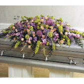 Superior Florist Ltd New York - The Full Couch Spray in shades of purple, lavender, and green is a vibrant and expressive casket spray designed to celebrate the life of a loved one. The combination of purple and lavender blooms, along with the lush greenery, creates a visually striking and harmonious display. This full couch spray serves as a beautiful and meaningful tribute, conveying sentiments of love, admiration, and remembrance. The rich and varied colors in this arrangement symbolize dignity, grace, and the enduring memories shared with the departed. It stands as a visual representation of the vibrancy of a life well-lived and a fitting expression of condolences during moments of grief.