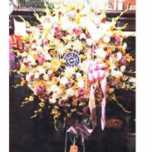 Superior Florist Ltd New York - A summery wreath with a plastic timepiece.