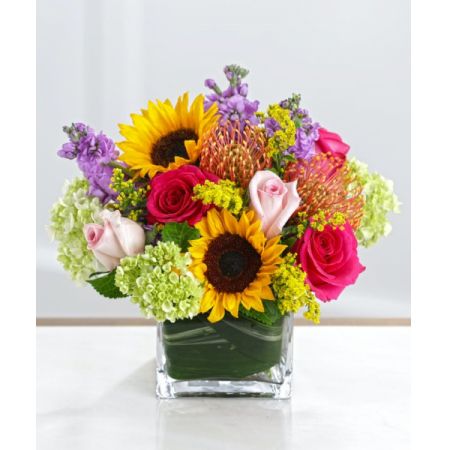 Superior Florist Ltd New York - The "Cube of Sunshine" is a delightful arrangement featuring sunflowers, roses, and hydrangea presented in a cube-shaped vase. With the option for same-day flower delivery, you can promptly share this cheerful and vibrant bouquet for various occasions. Whether it's to bring sunshine to someone's day, celebrate, or convey warm wishes, the "Cube of Sunshine" offers a visually stunning and joyful floral presentation. The combination of sunflowers, roses, and hydrangea creates a dynamic and colorful display, making it a perfect choice for those who appreciate the lively and natural beauty of sunlit blooms.