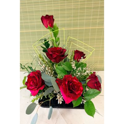 Uptown Blossoms Anchorage - Presenting 'Simply 6 Roses', a captivating bouquet of velvety, deep red roses, radiating classic romance and affection. 
These stunning blooms, nestled amongst delicate eucalyptus and textural accents, are artfully arranged in a sleek modern vase. 
Perfect for expressing heartfelt love, celebrating a special occasion, or simply brightening someone’s day with a touch of elegant beauty.
Send the timeless gift of roses – a symbol of passion and enduring devotion – with this exquisite arrangement.