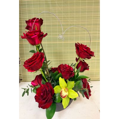 Uptown Blossoms Anchorage - Express your deepest affection with our Valentine Dozen with Orchids, a stunning bouquet of velvety red roses and exotic blooms. 
Deep crimson petals unfurl around graceful orchids, creating a captivating fragrance and a touch of modern elegance. 
Presented in a chic black vase and accented with lush greenery, this arrangement speaks volumes on its own.
Send a lasting symbol of love this Valentine's Day with this unforgettable dozen roses gift, perfect for that special someone. 