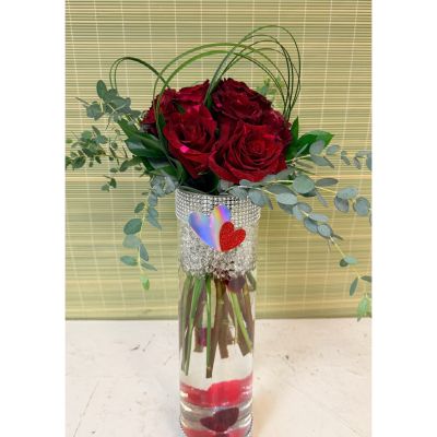 Uptown Blossoms Anchorage - One dozen roses in your choice of colors. Sheltered with lily grass and accented with red heart glass marbles and a blossom of cymbidium orchids. In tall cylinder vase that is now half price.  Deluxe would be 2 dozen roses.