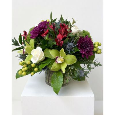 Uptown Blossoms Anchorage - Indulge in the rich beauty of the Uptown Upscale Vase, a stunning blend of deep burgundy mums, creamy white roses, and striking thistle.
This luxurious floral arrangement exudes sophistication, with delicate orchids and vibrant berries adding layers of texture and color.
Perfect for expressing heartfelt emotions, this bouquet will transform any space with its captivating fragrance and elegant presence. 
Send a touch of timeless charm with this unforgettable gift, ideal for anniversaries, celebrations, or simply to brighten someone’s day with premium flowers.