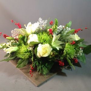 Bouquets Denver - Enrich your table with an exquisite oblong centerpiece featuring a harmonious blend of Evergreen, Fuji Mums, White Lilies, White Roses, Ilex Berries, Star of Bethlehem, and Peonies. This captivating arrangement combines a variety of textures and hues for a stunning visual impact. Elevate your space with the elegance of this diverse floral composition. Experience the convenience of same-day flower delivery, ensuring your centerpiece graces your event or home promptly. Embrace the festive spirit with the thoughtful inclusion of seasonal elements, creating a truly enchanting display. Delight in the beauty and variety that this carefully curated centerpiece brings to any occasion.





