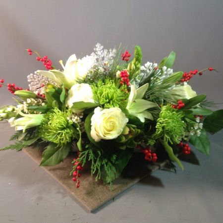 Bouquets Denver - Enrich your table with an exquisite oblong centerpiece featuring a harmonious blend of Evergreen, Fuji Mums, White Lilies, White Roses, Ilex Berries, Star of Bethlehem, and Peonies. This captivating arrangement combines a variety of textures and hues for a stunning visual impact. Elevate your space with the elegance of this diverse floral composition. Experience the convenience of same-day flower delivery, ensuring your centerpiece graces your event or home promptly. Embrace the festive spirit with the thoughtful inclusion of seasonal elements, creating a truly enchanting display. Delight in the beauty and variety that this carefully curated centerpiece brings to any occasion.





